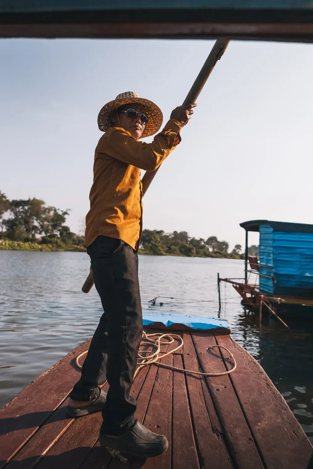 A boatman at the bow of a community boat on Tonle Sap Lake