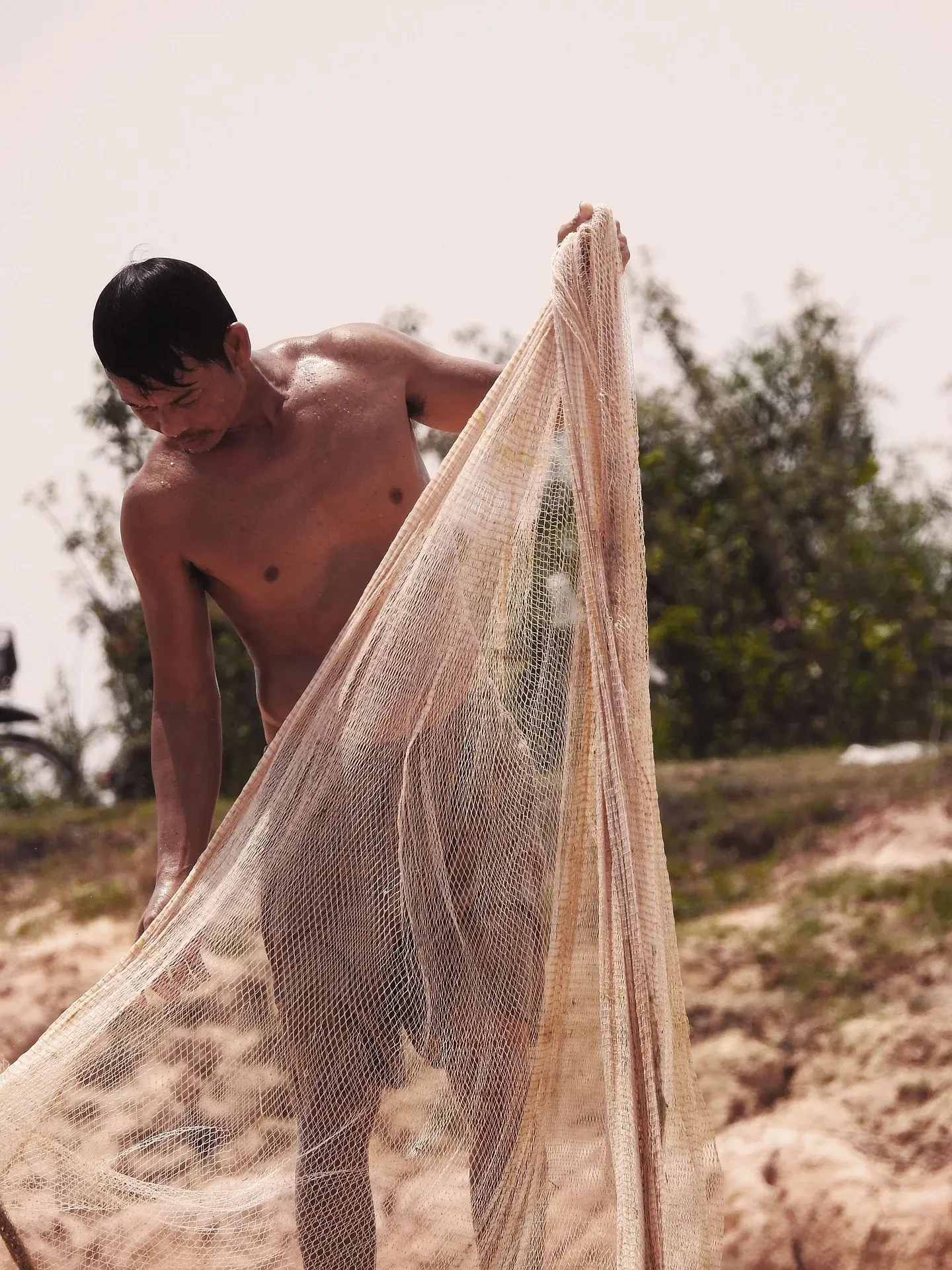 A fisherman lifting his net