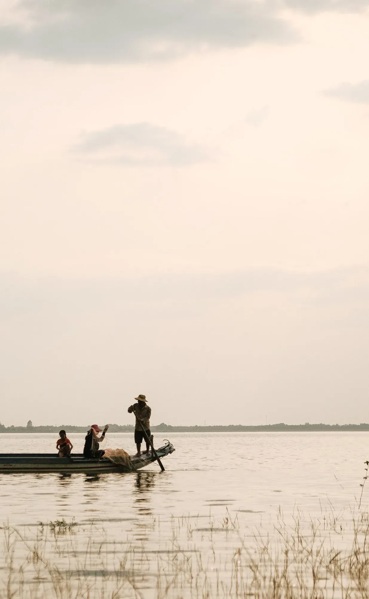 A fishing family on the lake at dusk