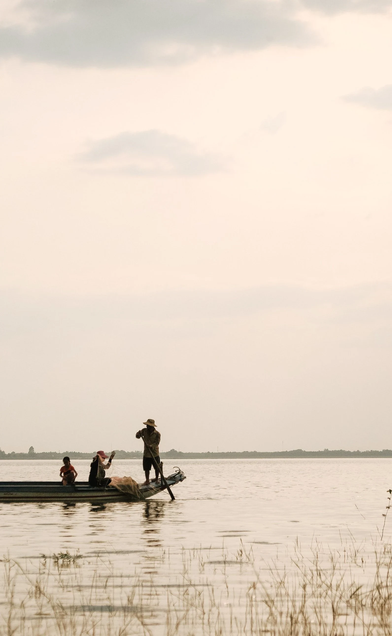 A fishing family on the lake at dusk