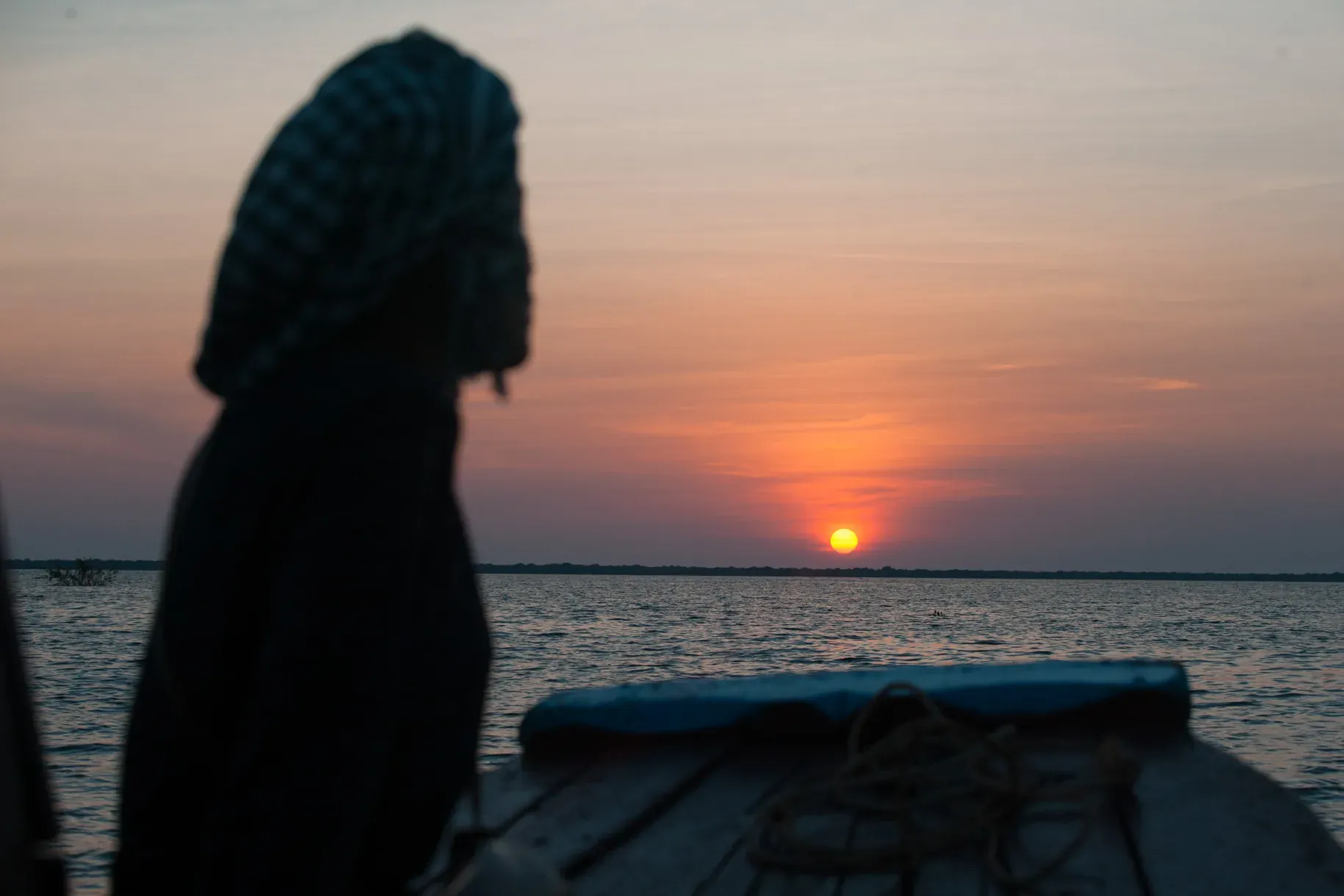 A boat silhouetted against the sunset on Tonle Sap Lake