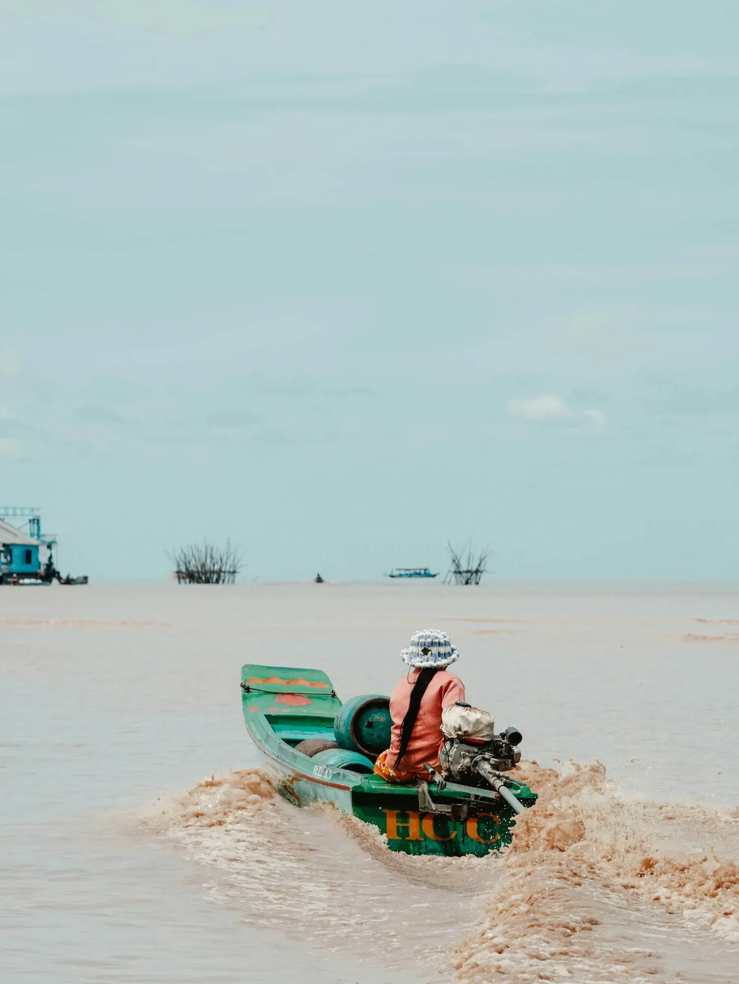 A boat heads out across Tonle Sap Lake towards the fishing stakes